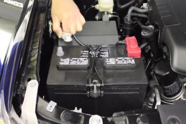 Photo of car battery being installed by mobile auto repair technician in Huntington Beach, California..